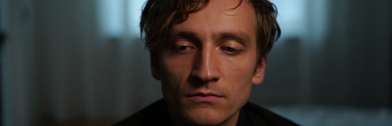 Мужчина грустно смотрящий вниз